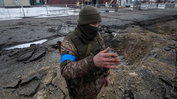 ▲▼烏克蘭蘇梅地區（Sumy）城鎮阿克提卡（Okhtyrka）遭轟炸，一名烏克蘭士兵站在炸彈擊落點旁。（圖／路透）