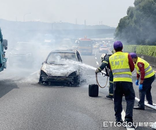 ▲中山高國道桃園北上45.9公里處16日上午發生轎車火燒車意外，消防人員正努力灌救。（圖／記者沈繼昌翻攝）