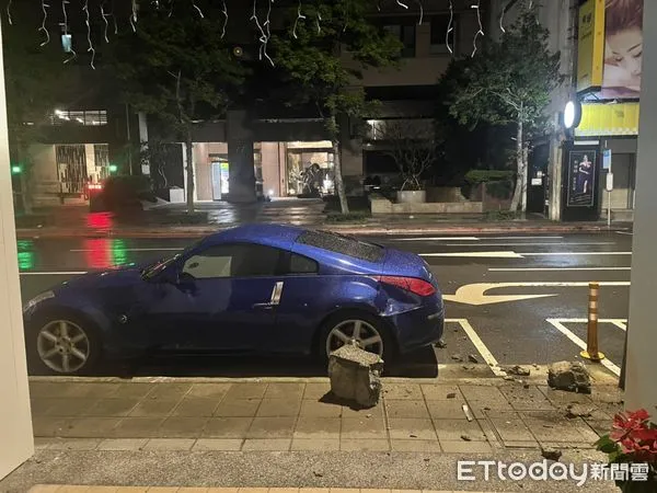 ▲21日凌晨中正區博愛路一輛停放路旁的日產350Z跑車遭外牆剝落水泥塊砸毀後葉子板、所幸並無人員受傷。（圖／記者張君豪翻攝）