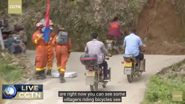 ▲東航事故現場山腳下，當地村民組成摩托車隊協助運送救災物資上山。（圖／翻攝CGTN）