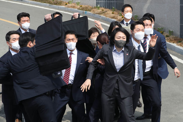 ▲▼40多歲男性丟擲燒酒酒瓶，維安人員隨即用肉身護住朴槿惠。（圖／達志影像／newscom）