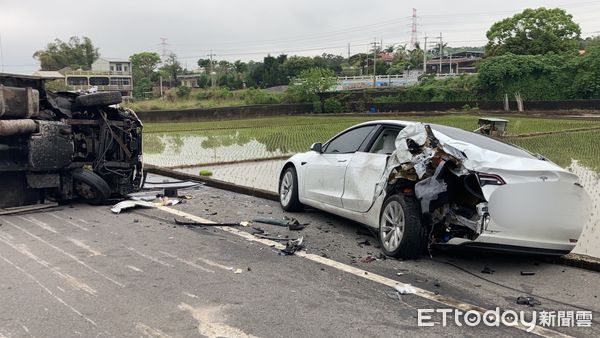 ▲小貨車撞上停放路邊的特斯拉後，因重心不穩而翻車，所幸駕駛只是飽受驚嚇。（圖／記者黃孟珍翻攝）