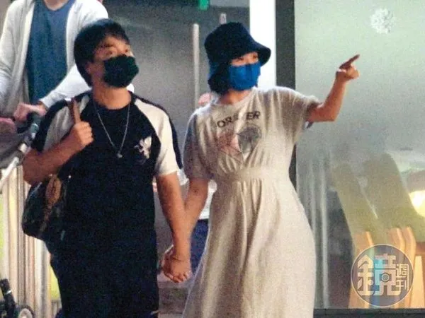 3/17 19:30 張峰奇（左）跟李亮瑾（右）手牽手從婦幼診所大門走出來，肚子明顯了。