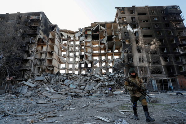 ▲▼一名俄軍在馬力波遭毀的公寓大樓徘徊。（圖／路透社）