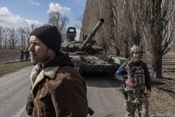 ▲▼ 烏克蘭士兵3月27日路過停放在基輔郊外盧基亞尼夫卡村（Lukyanivka）的一輛俄羅斯坦克。（圖／路透）