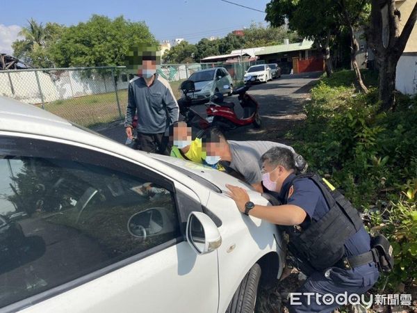 ▲東港警分局東港派出所副所長王天佑、警員黃光輝協助郭男自小客車脫困。（圖／記者陳崑福翻攝，下同）