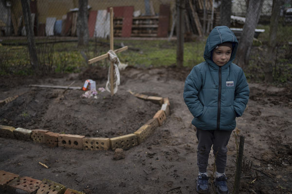 ▲▼烏克蘭首都基輔教郊區布查慘遭俄軍屠殺，6歲男童站在母親墳前，其死於戰爭中的飢餓與壓力。（圖／達志影像／美聯社）