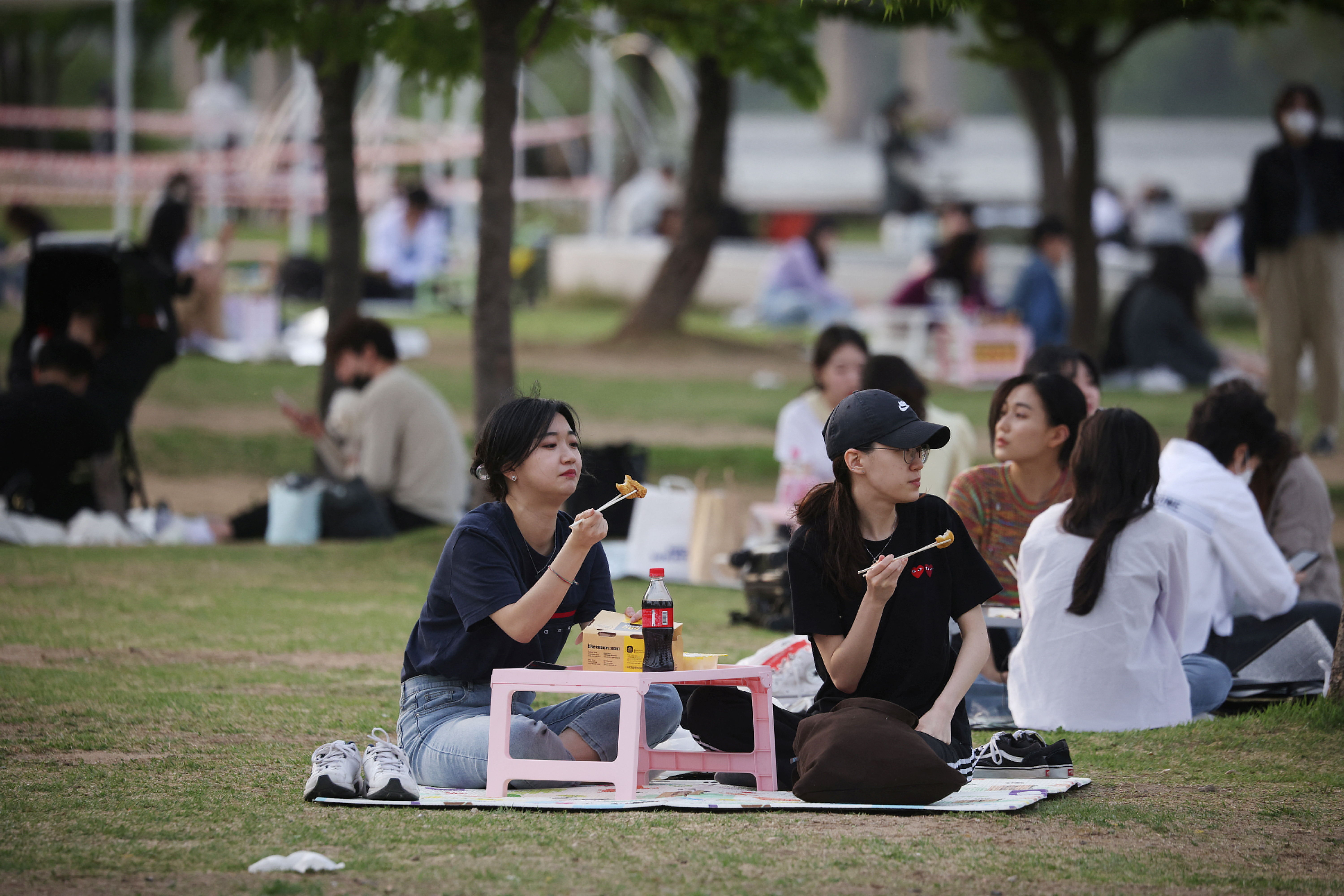 ▲▼南韓將從5月2日起解除戶外口罩令，圖為一群女人在首爾漢江公園野餐，彷彿回到疫情以前的日常生活。（圖／路透社）