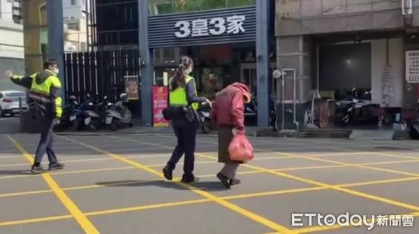 ▲母湯喔！阿嬤不走斑馬線硬闖中正路，兩員警急幫擋車護送「超帥氣」。（圖／民眾提供）