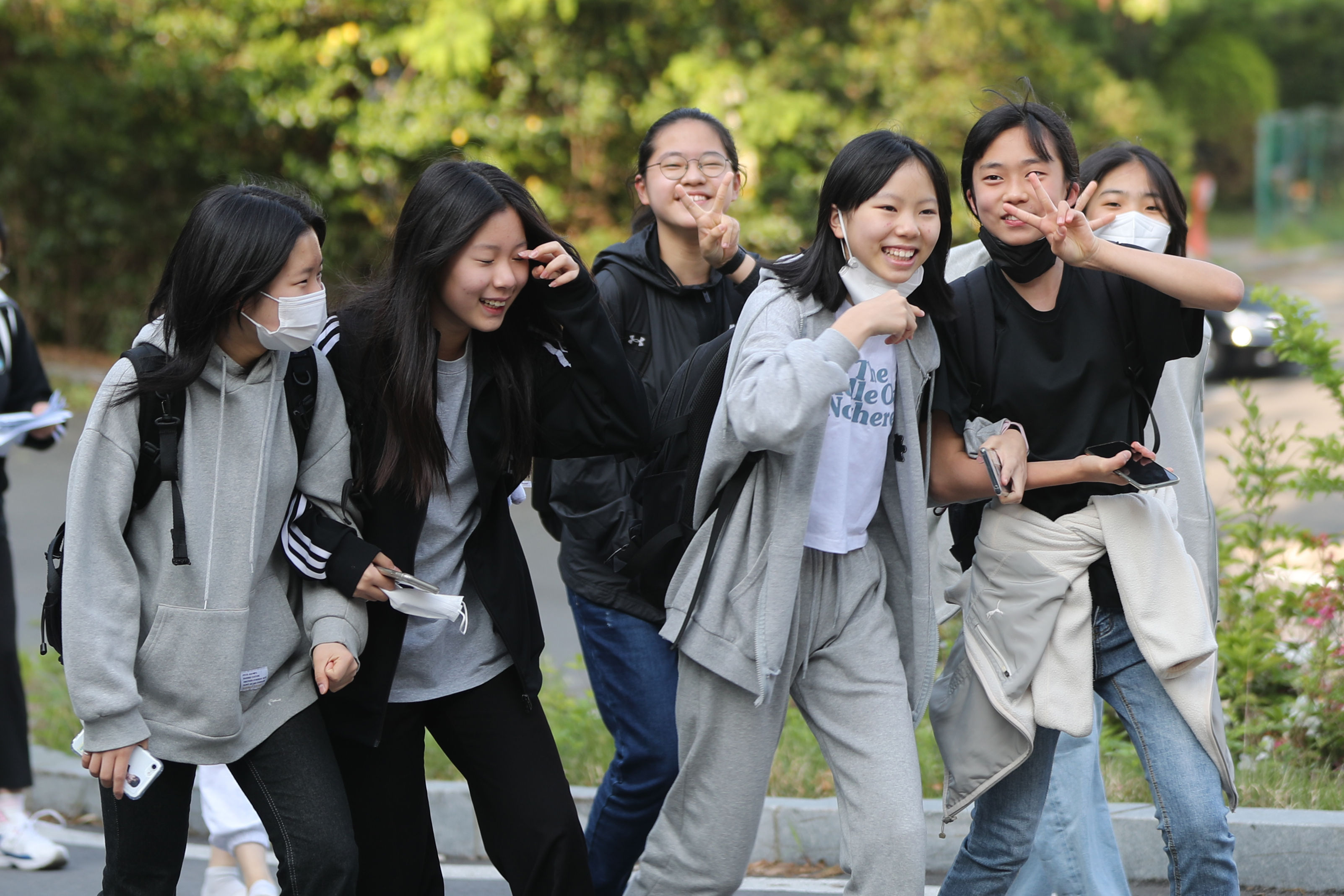 ▲▼南韓解除戶外口罩令，光州市一群國中少女走在戶外脫下口罩。（圖／達志影像／newscom）