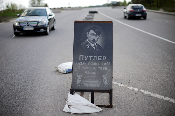 ▲▼烏克蘭基輔附近的高速公路上，有人擺設了一塊將普丁描繪成希特勒的模擬葬禮看板。（圖／路透）