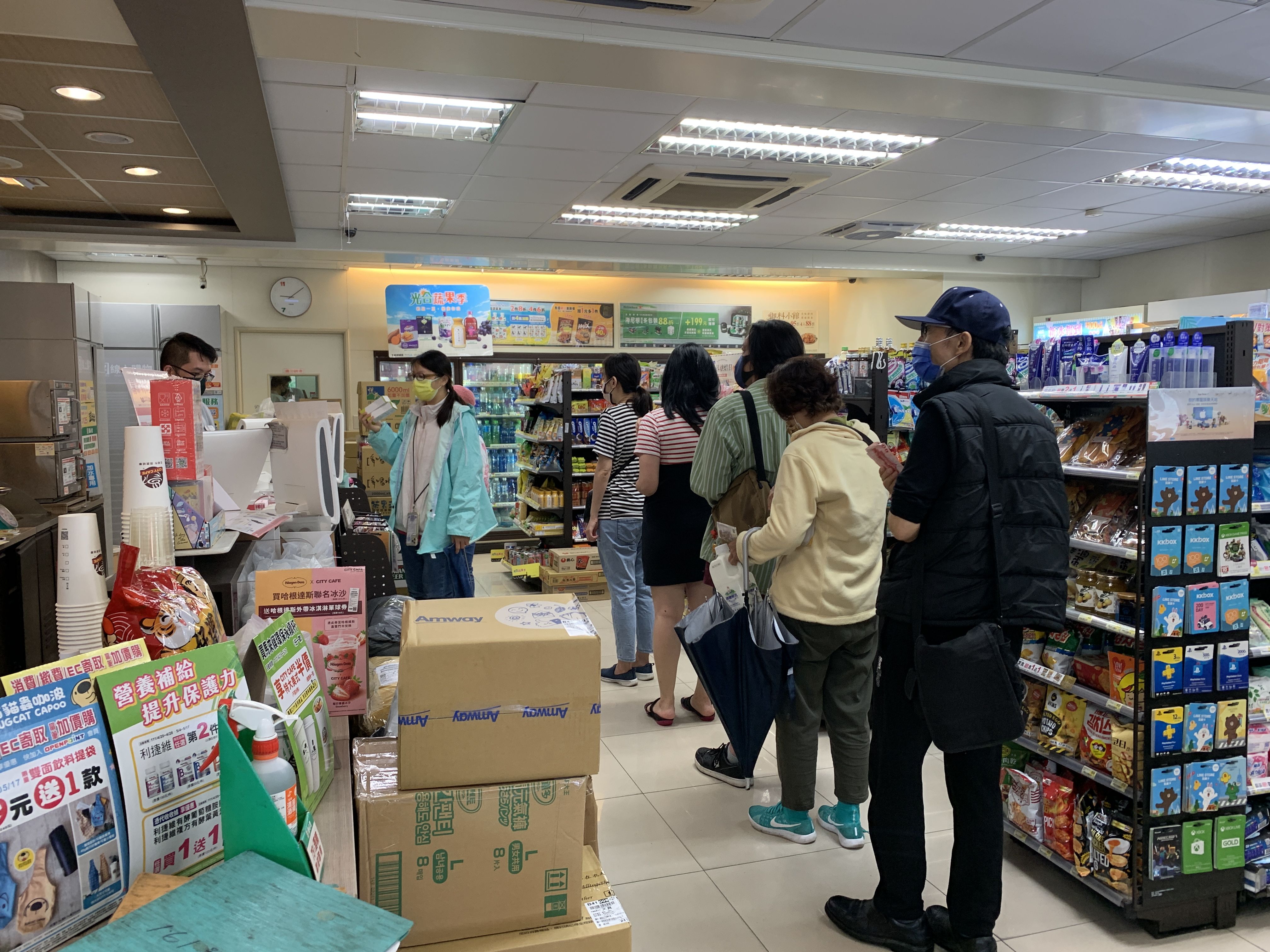 ▲▼7-11開賣唾液快篩，民眾冒雨排隊搶買。（圖／記者林育綾攝）