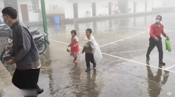 8歲小兄妹披塑膠袋冒雨20公里，只為開學前做1次免費篩檢。（圖／翻攝自微博／搜狐千里眼）