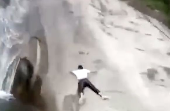 ▲安徽一名男子從瀑布上高速滑落，驚險畫面全被一旁民眾拍下。（圖／翻攝澎湃視頻）