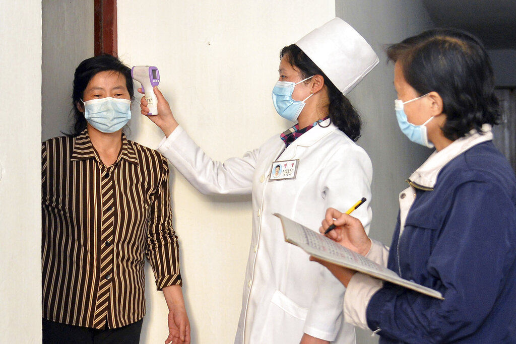 ▲▼北韓一名女醫師正在為平壤居民檢測體溫，全國聚焦在防疫工作。（圖／達志影像／美聯社）