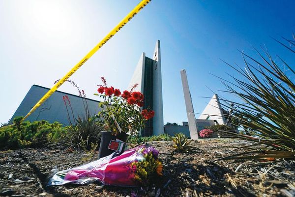 加州長老教會發生槍擊案後，警方圍起封鎖線，也有民眾獻花哀悼。（達志影像）