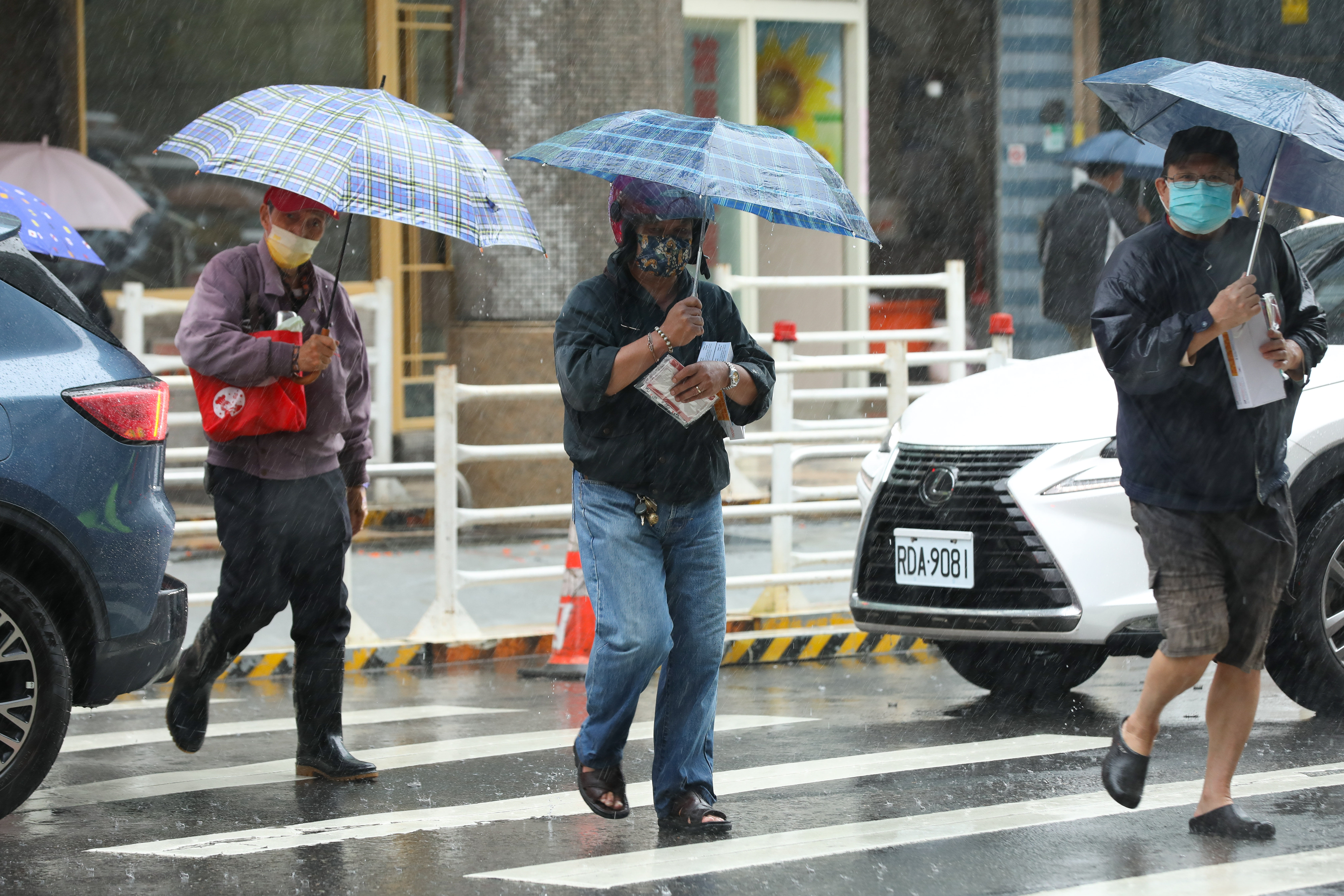 ▲▼天氣,行人,路人,口罩,流感,防疫,過馬路,斑馬線,過馬路,大雨,下雨,雨天,豪大雨,午後雷陣雨,梅雨,降雨,氣象,豪雨,颱風外圍環流,西南氣流,鋒面,撐傘,雨傘,溼冷,陰雨綿綿,潮濕,濕度,熱對流,天氣配圖。（圖／記者李毓康攝）