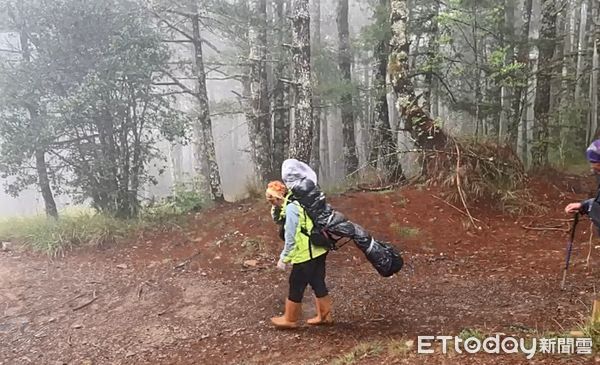 ▲搜救人員以徒步方式將遺體揹下山。（圖／記者蔡文淵翻攝）