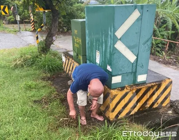 ▲在變電箱後面尋獲正低頭拔草把玩的陳姓老翁。（圖／記者楊漢聲翻攝）