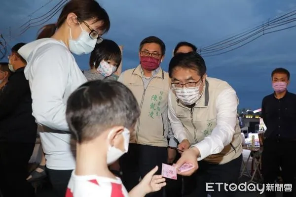 ▲台南市長黃偉哲出席夜市首場「銅板快閃夠購go」，發放每份面額50元的夜市券，民眾領券後，十分開心地在新永華夜市品嘗各種美味小吃。（圖／記者林悅翻攝，下同）