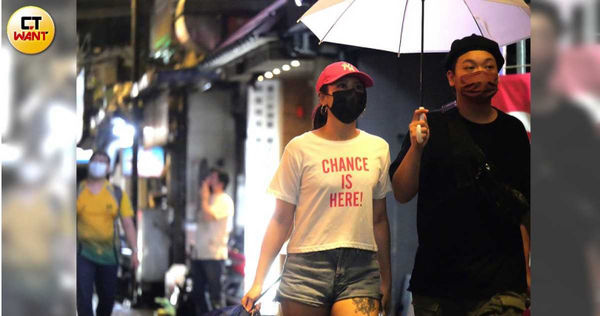 雖然女伴自己手上有拿著一把折傘，但卻跟阿虎並肩共撐一把雨傘。（圖／本刊攝影組）