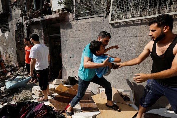 ▲▼以色列空襲一所房屋後，巴勒斯坦人搶救一名男孩。（圖／路透）