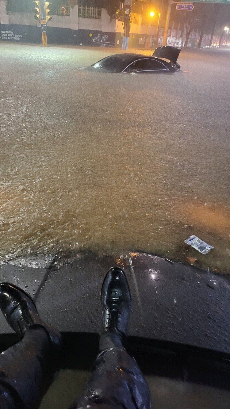 ▲▼首爾災難暴雨，西裝男困車頂成焦點。（圖／翻攝推特「@lora5102」）