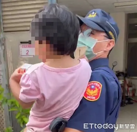 ▲暖警單手抱起迷途女童挨家挨戶尋找。（圖／中壢警分局提供）