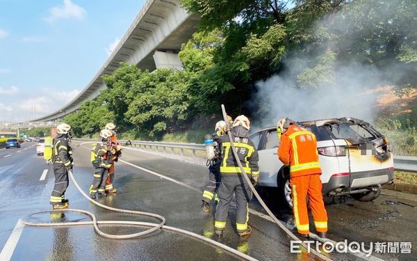 ▲國一南下楊梅幼獅路段17日上午7時許1輛白色轎車引擎冒煙，消防人員全力灌救。（圖／記者沈繼昌翻攝）