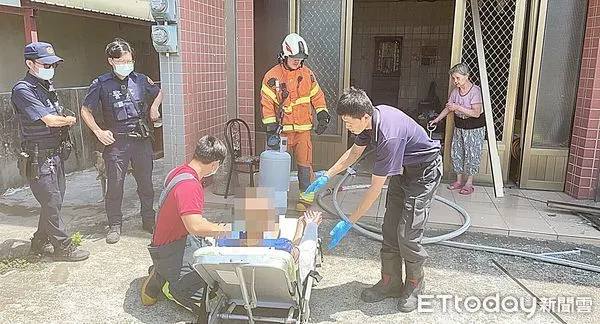 ▲桃園市觀音區某民宅16日上午發生瓦斯氣爆，消防人員到場後火勢已熄滅，消防人員為受傷的徐姓老翁包紮傷口，民宅大門被氣爆震壞。（圖／記者沈繼昌翻攝）