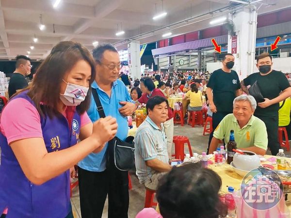 新北市議員劉美芳到餐會拜票時，遭多名黑衣人（箭頭處）跟蹤尾隨。（讀者提供）