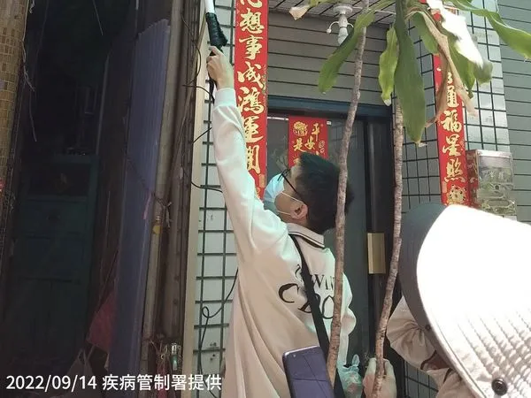 ▲▼防疫人員於高雄市前鎮區執行孳生源查核，運用磯玉柄協助民眾檢視家戶外遮雨棚是否有積水產生孑孓或蚊卵。（圖／疾管署提供）