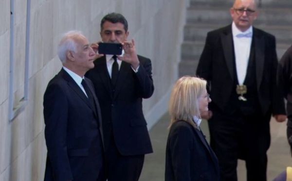▲▼亞美尼亞總統哈恰圖良18日在西敏廳向女王靈柩鞠躬時，不顧規定和助手玩起擺拍，引發眾人不滿。（圖／翻攝自推特）