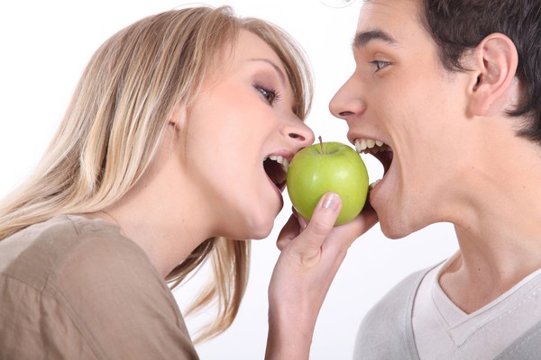 男女一起吃蘋果。（達志示意圖）