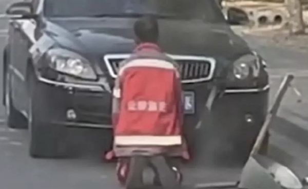 ▲一名上了年紀的清潔工人跪在黑色轎車前，影片曝光後讓網友心疼。（圖／翻攝九派視頻）