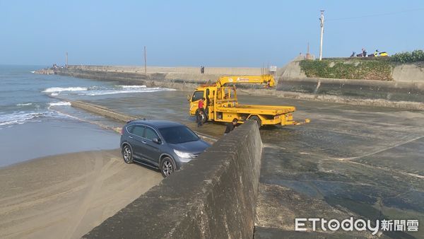 ▲▼釣客在通霄新埔漁港釣魚，未注意漲潮致車輛受困，警方找來拖吊車以吊掛方式協助脫困。（圖／警方提供）