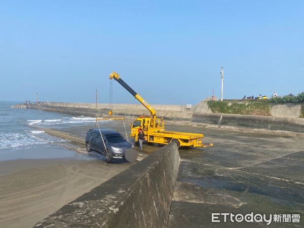 ▲▼釣客在通霄新埔漁港釣魚，未注意漲潮致車輛受困，警方找來拖吊車以吊掛方式協助脫困。（圖／警方提供）