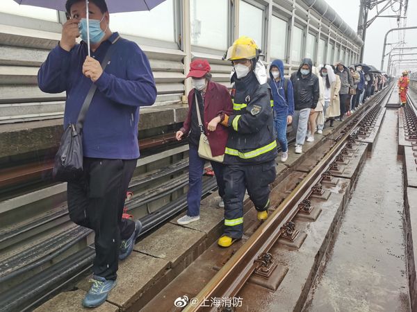 ▲上海地鐵出現事故後，後方列車乘客從軌道上疏散。（圖／翻攝澎湃新聞）