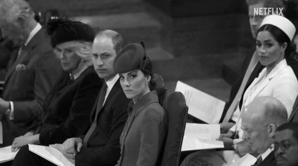 凱特王妃面惡凶狠盯著前方，威廉王子、王后卡蜜拉、查爾斯三世坐在旁邊，哈利與梅根就坐在這些人後方，「決裂」之意不言而喻。（翻攝Netflix）