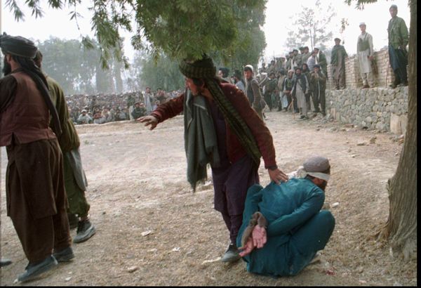 ▲▼1996年2月，在阿富汗霍斯特省，塔利班成員準備公開處決蒙眼坐著的穆罕默德烏拉，此人涉嫌謀殺計程車司機而被判刑。（圖／達志影像／美聯社）