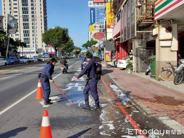 ▲台南市中華西路二段與民權路三段口至中華西路二段，因小貨車上貨物洗手乳罐不慎脫落破裂，整個路面滑溜影響往來機車騎士通行安全，警方戒護清洗。（圖／民眾提供，下同）