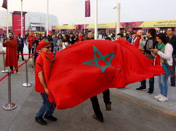▲▼摩洛哥球迷10日在對上葡萄牙的世足4強賽前，於卡達體育場外與摩洛哥國旗合影。（圖／路透）