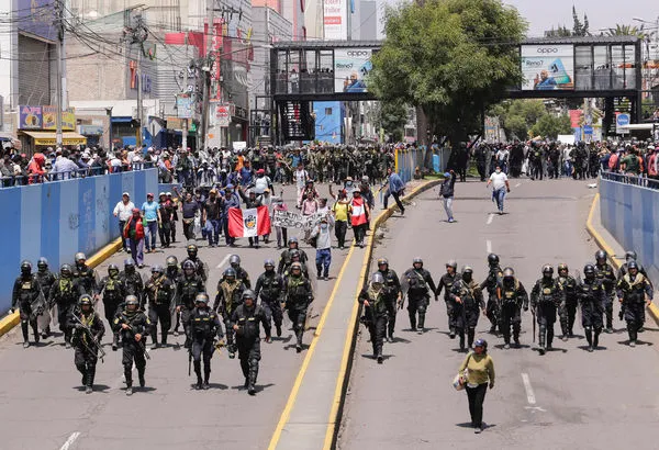 ▲▼秘魯14日宣布全國進入緊急狀態。圖為14日警方與抗議人群走在秘魯的街道上。（圖／路透）
