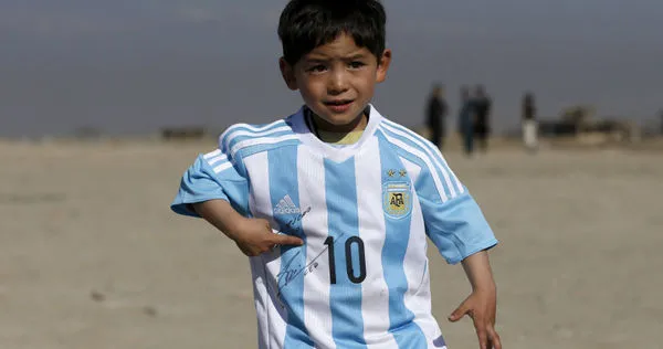 阿富汗男童阿瑪迪穿著有梅西簽名的球衣。（圖/達志/路透社）