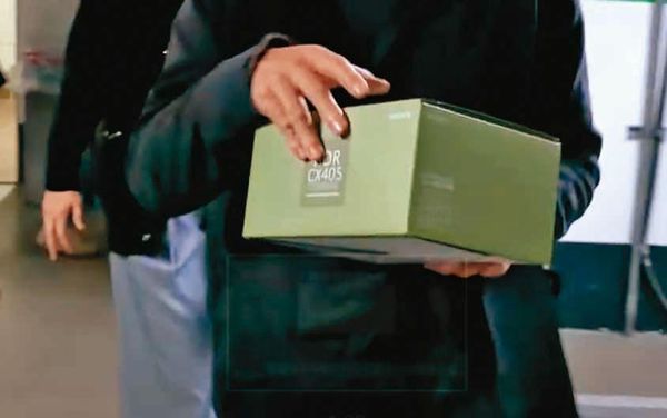 檢調搜索高辦時，拿走一個裝有關鍵證據的綠色紙盒。（翻攝《鏡新聞》）