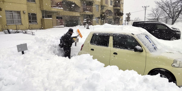 ▲▼  北海道札幌24日下雪，民眾在停車場清理積雪。（圖／路透）