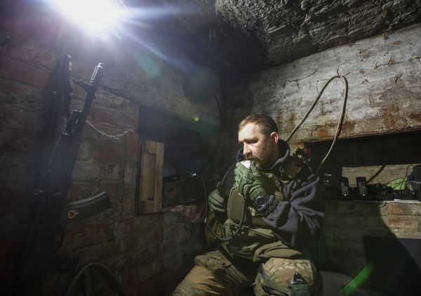 ▲▼一名烏克蘭軍人在他們前線陣地附近的避難所中使用無線電台。（圖／路透）
