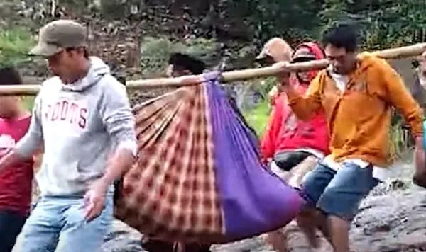 ▲▼印尼一名孕婦被村民們以紗籠布代替擔架，抬到7公里外的醫院急救。（圖／翻攝自YouTube）