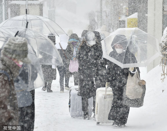 ▲▼ 日本北海道札幌21日降雪，民眾撐傘出門。（圖／CFP）