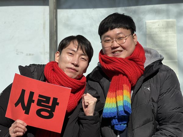 ▲▼南韓「同性夫夫」金永旻、蘇成旭21日在健保訴訟二審中取得勝訴，他們表示，終於能自信喊道「愛戰勝歧視」。（圖／Facebook@gagoonet）